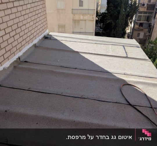 גג אטום עם חומר איטום לבן לאורך הקיר